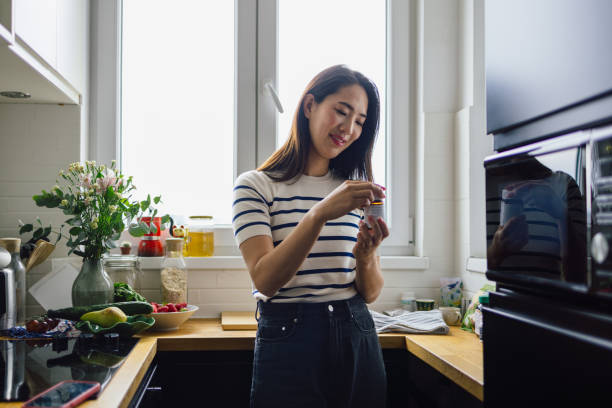 istock Smiling Asian Woman Taking Nutritional Supplements 1546277539