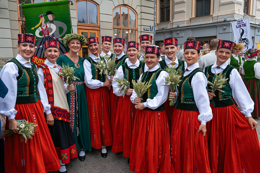Riga, Latvia - June 2, 2023: Parade participants in folk costumes on the streets of the Old Town before the march