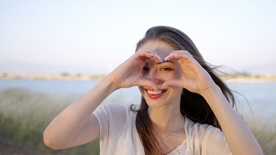 Woman making heart symbol with her hands.