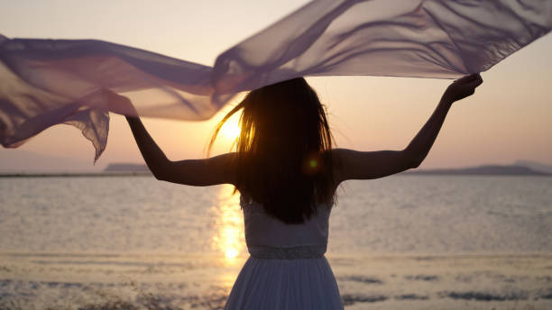 istock Young woman waving silk in air 1546318716