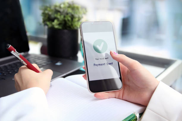 istock Woman using online banking on mobile phone. Payment sent. 1546323879