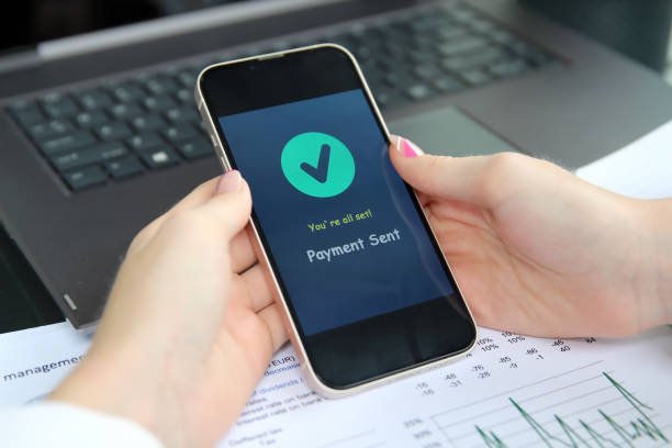istock Woman using online banking on mobile phone. Payment sent. 1546325438