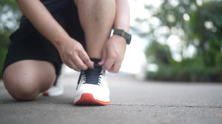 Male athlete tying shoelaces at the park