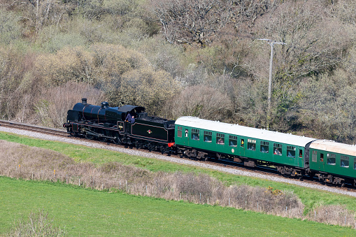 Summer view of a beautiful green steam locomotive against blue sky