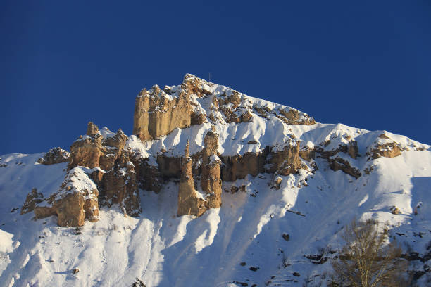 High peaks covered with snow in the North of Lebanon with unique rocks and a crucifix on top,