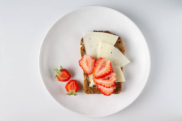 istock sandwich with cheese and strawberries on whole grain bread, on a white round plate, copy space 1546439260