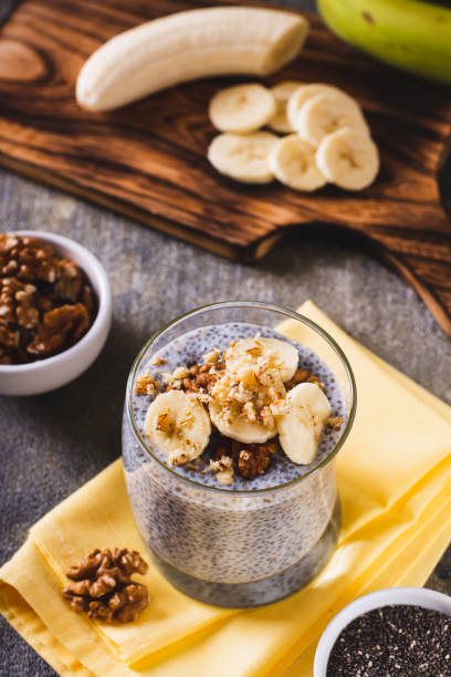 istock Chia seeds pudding with fresh banana and walnuts in a glass on the table vertical view 1546441318