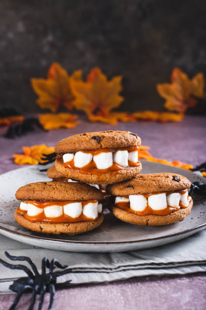 istock Gingerbread cookies with marshmallow teeth on a halloween plate vertical view 1546441875