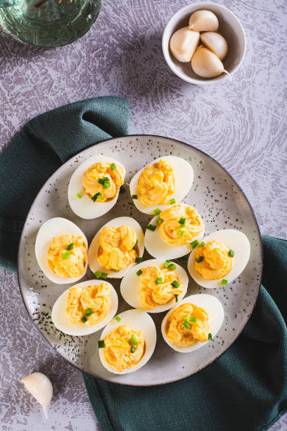istock Boiled eggs stuffed with yolk, cheese, garlic and mayonnaise on a plate top and vertical view 1546442335