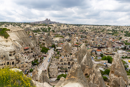Cityscape of ancient Goreme city in Cappadocia, Turkey. Old cave houses coexist with typical houses. Popular travel destination in Turkey.