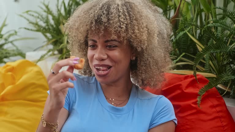 African American Woman Eating Onion Ring at Cafe