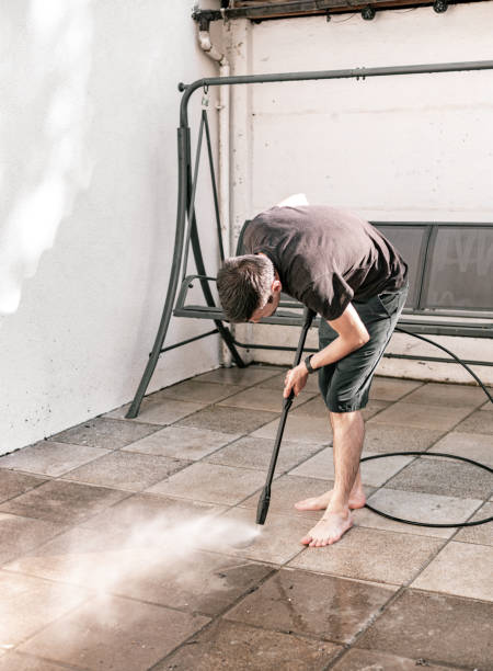 istock A young guy washes garden tiles in the backyard with a kercher. 1546724880