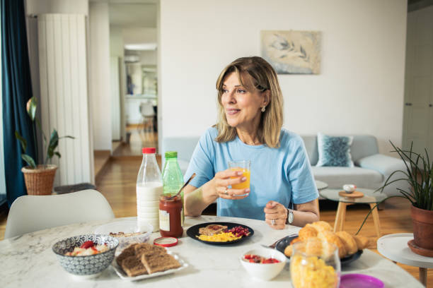 istock Middle-aged woman is having breakfast at home 1546750994