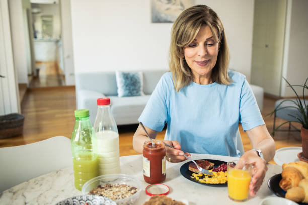 istock Happy mature woman is having breakfast 1546751004