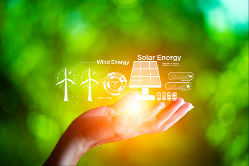Hand holding with  green energy, wind energy, solar energy icon on blur green leaf. carbon neutral and green natural background  with energy icon around it. Carbon gas affects global warming.