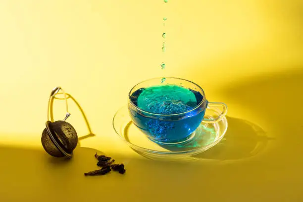 Photo of Blue tea or Butterfly tea on yellow background, popular Asian caffeine free herbal drink for health and detox