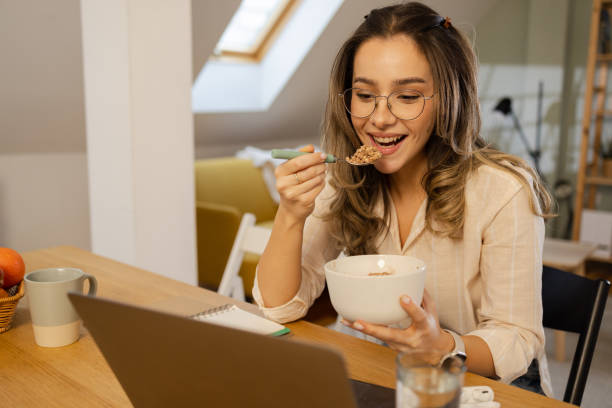 istock Happy young woman having a breakfast during her work from home 1546804197