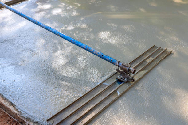 the concrete for driveway is being leveled by workers on construction site using mix concrete trowels - concrete driveway cement construction imagens e fotografias de stock