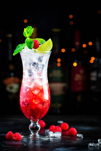 istock Raspberry lemonade cocktail or mocktail drink with raspberries, syrup, soda, lime, mint and ice, dark bar counter background, copy space 1547023158