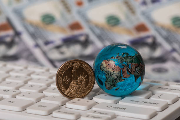 istock Glass globe on a computer keyboard against the background of 100 US dollar bills 1547101297