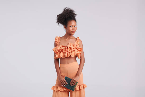 Literary Glamour: Black Girl in Orange Shirt Posing with Book