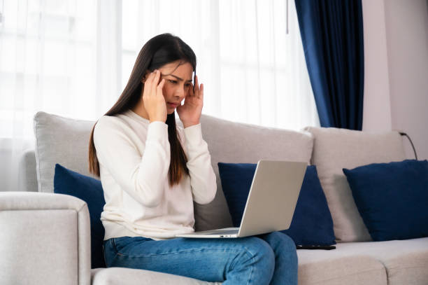 istock Office syndrome. Overworked tired young asian woman feeling headache, having eyesight problem after computer laptop work. Stressed young woman suffering from fatigue at home 1547293181