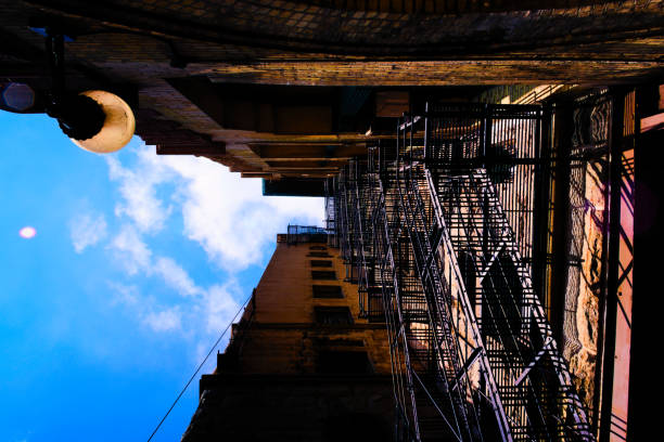Dramatic view of a fire escape against a brick building with a deep blue sky overhead. High quality photo