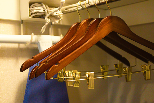 Iconic empty hotel hangers and ironing board hanging in the closet. High quality photo