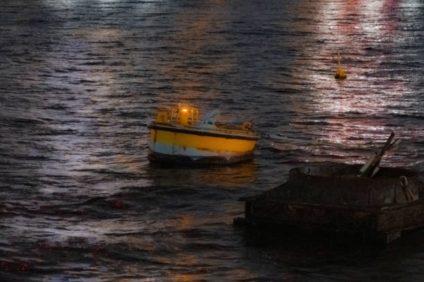 On a July night, a lone boat is rolling and swaying with the waves