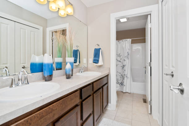 Spacious Modern Bathroom With Double Vanity Marble Countertop, Dual Mirrors And Glossy Tile Creating Clean,