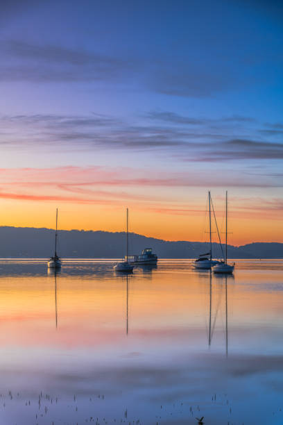 istock Beautiful sunrise waterscape with high cloud, reflections and boats 1547429557
