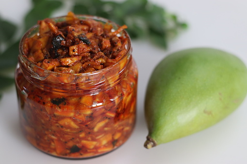 Kadumanga achar. Kerala style instant mango pickle made of chopped unripe raw totapuri mangoes, with mustard leaves, curry leaves and spices. It is a part of traditional Kerala sadya