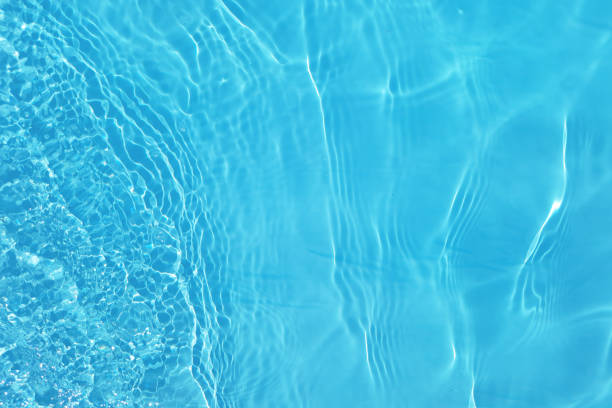 istock Blue water with ripples on the surface. Defocus blurred transparent blue colored clear calm water surface texture with splashes and bubbles. Water waves with shining pattern texture background. 1547563149