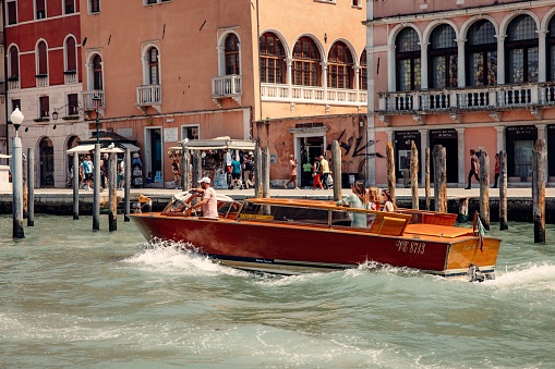 Venice, Italy – June 14, 2023: A group of diverse tourists enjoying a scenic gondola ride through the Grand Canal in Venice, Italy