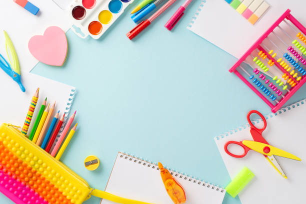 istock Embark on learning adventure with this top view composition: delightful collection of vibrant stationery set against pastel blue background, with round copyspace available for text or advertisements 1547637331