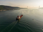 Aerial view tanker ship with liquid bulk cargo in transit at sunrise.
