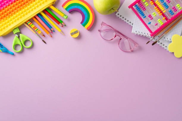 istock Engage in early childhood education with this captivating top-down image: an assortment of colorful child stationery arranged on violet isolated background, offering copyspace for text or advertising 1547653597