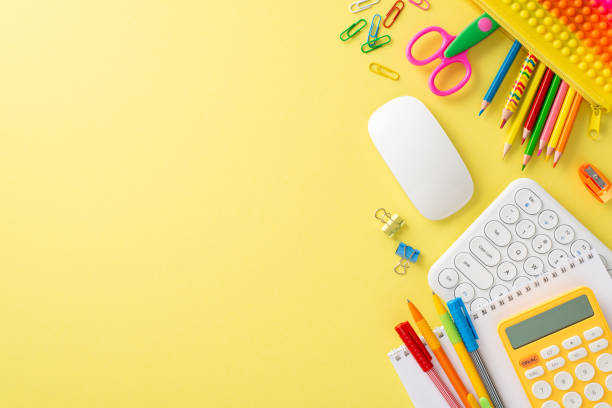 istock Step into the world of online studying from home with this captivating top-down view, presenting a keyboard, mouse and colorful stationary on yellow background. Copyspace for text or advertisement 1547654643