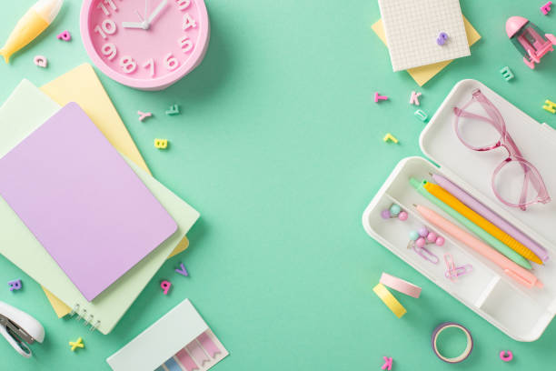 istock Prepare for productive school year with visually pleasing display. Explore assortment of girly supplies from top view. Notepads, pencil case, letters arranged on teal backdrop, offering space for text 1547655674
