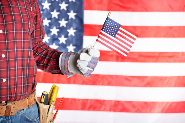 istock Carpenter in protective gloves and toolbelt with us flag labor day background 1547738898