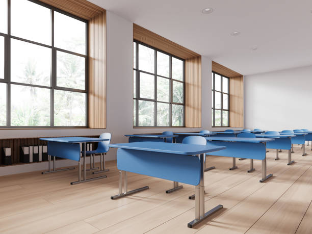 istock Cozy minimalist classroom interior with blue desk in row and panoramic window 1547759614