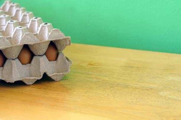 istock Eggs in carton box on wooden table with copy space. 1547762659