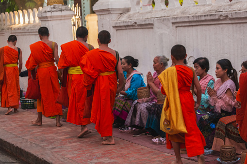 Luang Prabang, Laos.　\nThe entire ancient city of Luang Prabang is a World Heritage Site.　\nAlms giving in Luang Prabang has been around for hundreds of years.\nEvery morning, barefoot monks in saffron robes walk the streets to receive alms from local residents.\nSince temples in Laos do not open for cooking, the monks' daily food comes from people's alms, which is a sacred and solemn act in Lao people's mind.\nThese are real scenes every morning, not performances.