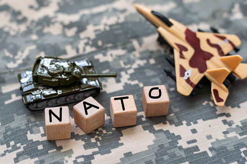 War NATO text on camouflage background. High quality photo