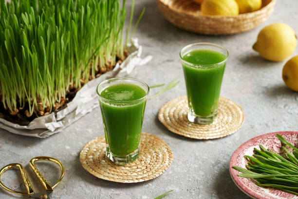 istock Fresh green barley grass juice in glass cups 1547906673