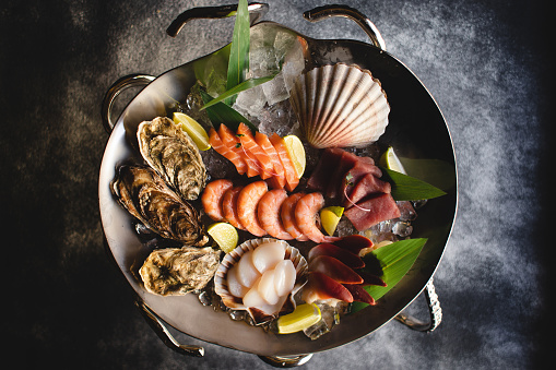 Restaurant serving seafood. Stylish food photography. asian food. Octopus tentacles, fish, shrimp, oysters
