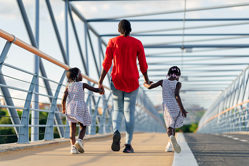 Black woman walking with her daughters