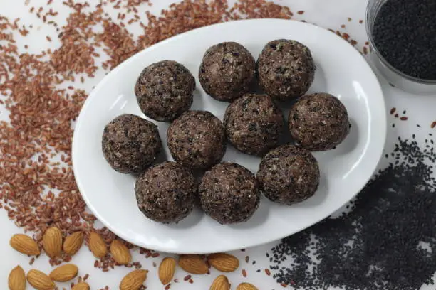 Navara til laddu. Sweet ball made of roasted and ground navara rice, roasted sesame seeds, jaggery and grated coconut flavored with cardamom. Healthy snack from Kerala. A Different version of ariyunda