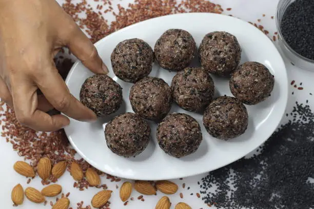 Navara til laddu. Sweet ball made of roasted and ground navara rice, roasted sesame seeds, jaggery and grated coconut flavored with cardamom. Healthy snack from Kerala. A Different version of ariyunda