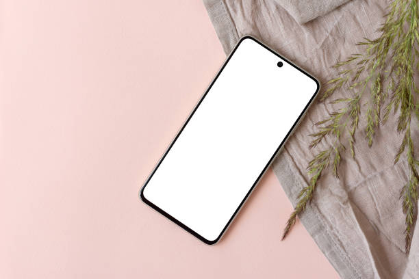istock Blank smartphone display mockup, linen fabric, meadow grass on light pink background, copy space. Aesthetic business brand template. 1548012315